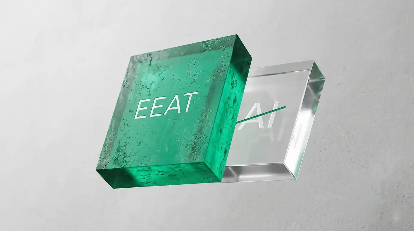 Representación minimalista en 3D de dos bloques abstractos: un bloque grande y texturizado de color verde esmeralda con el grabado 'E-E-A-T' en primer plano, y un bloque más pequeño, liso y transparente con el símbolo 'AI' tachado en segundo plano. Metáfora visual de la autoridad humana (E-E-A-T) frente al código genérico de IA penalizado por Google.